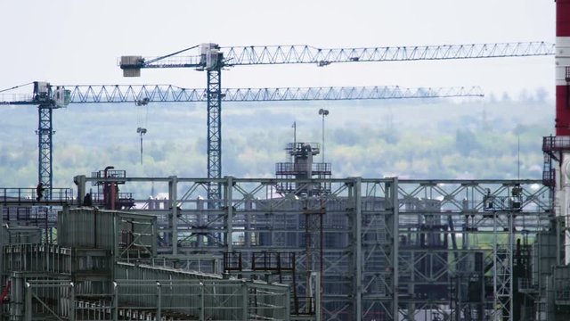 Long shot of oil refinery units in sunny weather with clouds in background. Gas industry background.