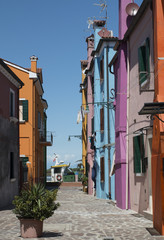 Fototapeta na wymiar A narrow street with colourful houses in Burano, Italy