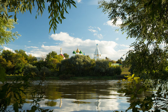 Beautiful Landscape Of Temples And Belltower On Assumption Cathedral Square Under Blue Sky With Dramatic Clouds By Embankment River In Sunny Summer Day In Kolomna, Moscow Region.