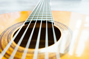 Classic acoustic guitar at weird and unusual perspective closeup. Six strings, free frets, sound...