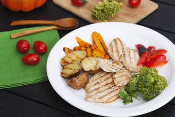 pieces of chicken fillet grilled and vegetables on a plate