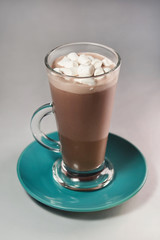 a delicious and hot cocoa drink with marshmallows in a large glass, a real autumn drink