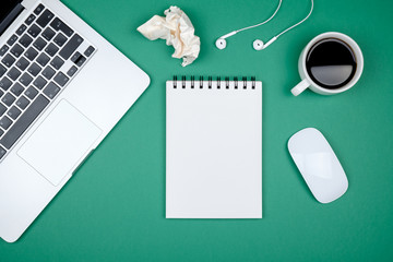 Modern designer office desk table with blank notebook page, laptop computer and cup of coffee