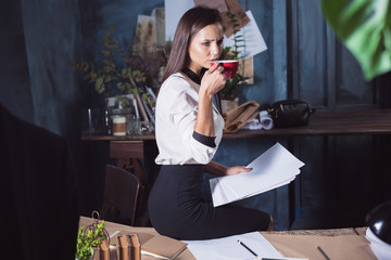 Young beautiful woman working with cup of coffee