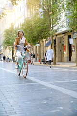 Senior woman riding city bike in town