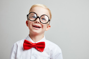Kind mit Brille und Fliege als Schüler