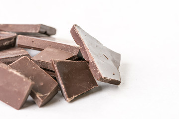 Slices of cooking chocolate on the white marble background table