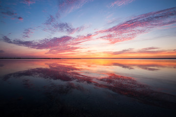 Fototapeta na wymiar Dramatic colorful sunset over the lake