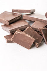 Slices of cooking chocolate on the white marble background table