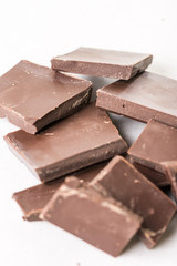 Slices of cooking chocolate on the white marble background table