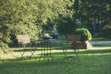 Table and chairs at summer green garden