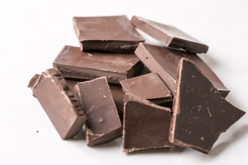 Slices of cooking chocolate on the white marble background table
