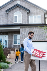 realtor with sale signboard