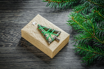Fir branch packed gift box on wooden board