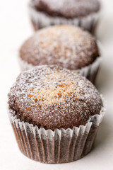 Chocolate brownies cup cakes with powdered sugar on the white marble background