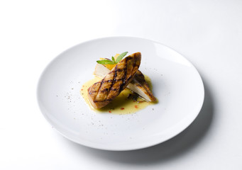 Grilled chicken fillet with orange mint sauce on a white plate