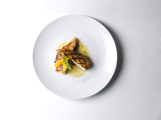 Grilled chicken fillet with orange mint sauce on a white plate