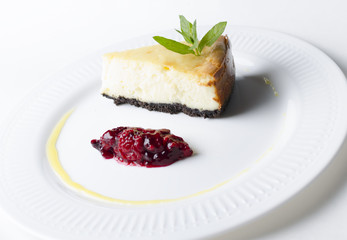 Classic cheesecake with cherry sauce on a white plate