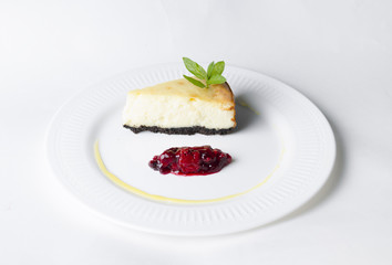 Classic cheesecake with cherry sauce on a white plate