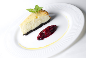 Classic cheesecake with cherry sauce on a white plate