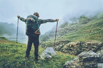 Happy Man backpacker hiking in foggy mountains raised hands Travel Lifestyle adventure wanderlust concept summer vacations active outdoor