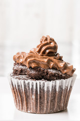 Chocolate cup cake with ganache chocolate cream on the white square plate