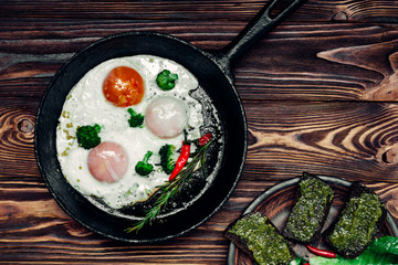 egg in a frying pan and a sandwich with pesto