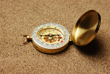 compass on a sandy beach