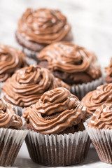 Plate full with chocolate cup cakes and with ganache chocolate cream