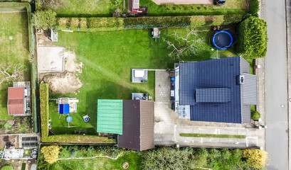 Single house in a new building settlement with houses and properties with gardens, aerial photo