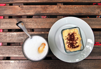 Glass of cafe latte and piece of tiramisu