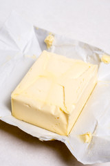 Slice of butter on the paper above white marble table