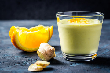 Clean and healthy golden milk orange ginger smoothie. Selective focus, copy space.