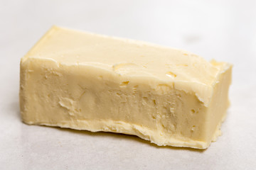 Slice of butter on the paper above white marble table