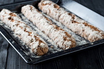 Three freshly baked baguette of biscotti on baking tray
