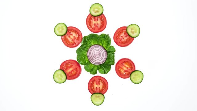 Top view on vegetable slices dancing on white background. 4k stop motion animation loop.