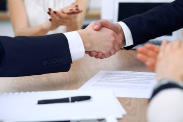 Close up of business people shaking hands at meeting or negotiation in the office. Partners are...
