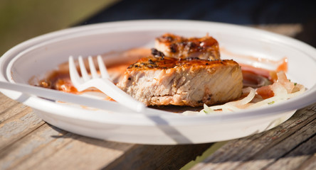 fried meat on coals in a plastic plate