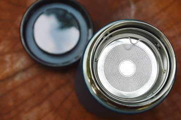 metal tea glass with stainless filter on wooden table