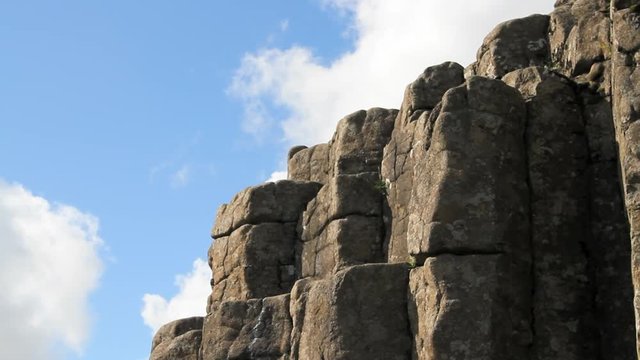 Basalt rock columns and blue sky with white clouds