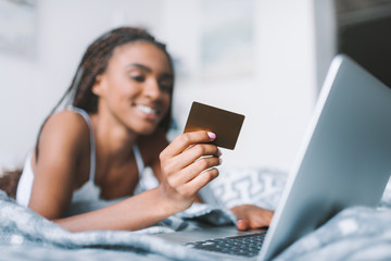 woman making e-shopping in bed