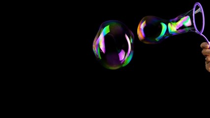 Hand making colorful soap bubbles background. Slow motion.
