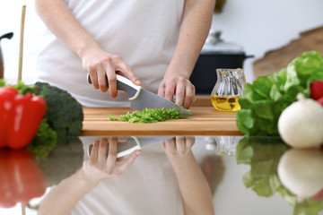 Close-up of  human hands  cooking in a kitchen. Friends having fun while preparing fresh salad....