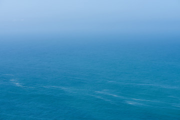 Aerial view of calm infinite ocean and blue sky background