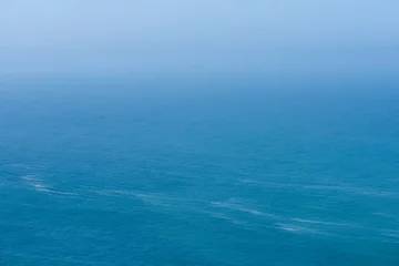 Afwasbaar Fotobehang Oceaan golf Aerial view of calm infinite ocean and blue sky background