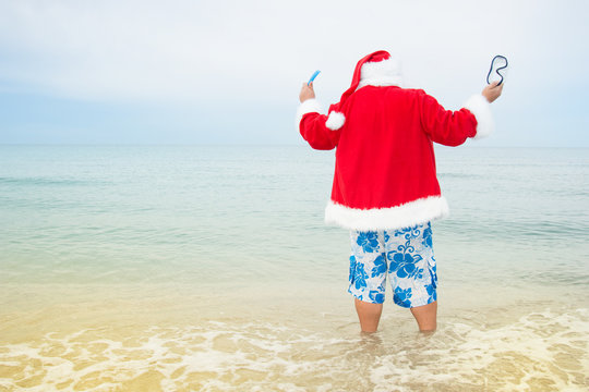 Funny Santa claus in the sea. Christmas in the tropics. 