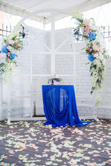 white wedding arch decorated with flowers and cloth