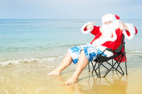 Funny Santa in shorts on the beach.