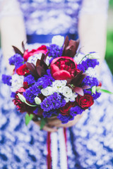 wedding bouquet in bride's hands in purple dress