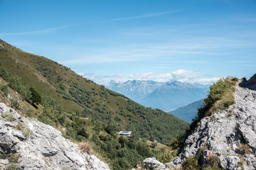 Fototapeta na wymiar Blick von der Pizzo Copa 1420 mü NN über das Rasthaus Rifugio, im Hintergrund die schweizer Alpen 